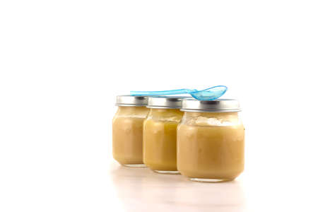 Three jars of fruit puree with a plastic spoonの写真素材