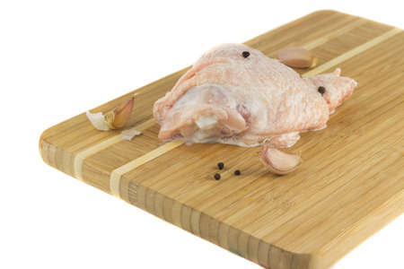 Chicken thighs on wooden board in a sauce with pepper and garlの写真素材