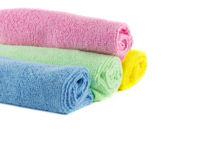 A roll of green, blue, pink and yellow towels on a white backgroundの写真素材