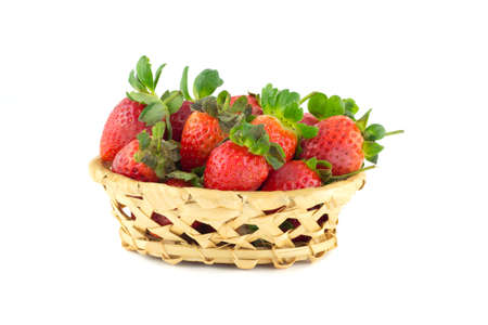 Handful of strawberries in a wicker basket on a white backgroundの写真素材