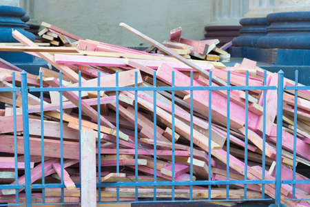 Pink planks piled in a heap on the steps of the building of the fenceの写真素材