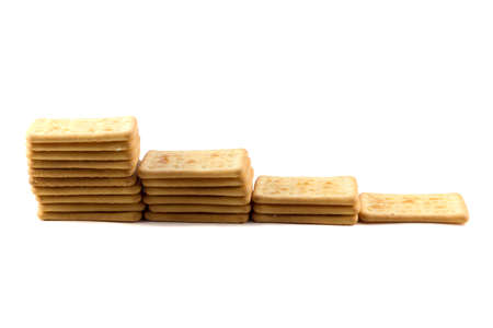 Cookies crackers stacked tower ascending on a white backgroundの写真素材