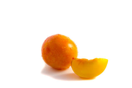 Yellow plum whole and one slice on a white backgroundの写真素材