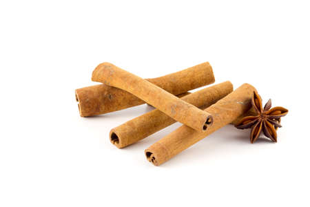 Cinnamon sticks and a few pieces of anise on a white backgroundの写真素材