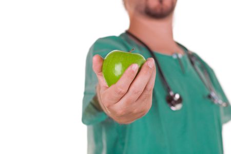 Doctor with a green apple on his handの写真素材