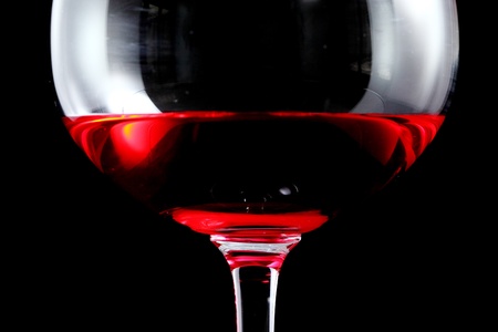 Red wine in glass on black isolate close up