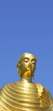 Golden buddha statue in Thailand, isolated against blue skyの写真素材