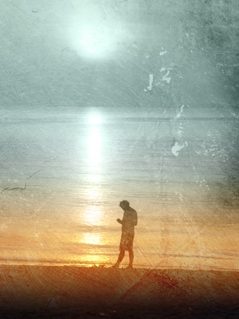 Sad man standing at the beach at sunsetの写真素材