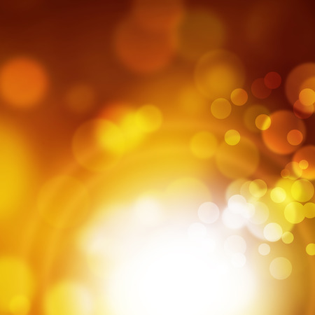 Abstract blurred bokeh background in yellow gold brown colors with white light effectの写真素材