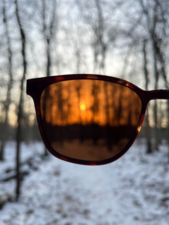 Sunglasses on a background of the sunset in the winter forest.
Sunglasses became a filter, and the...