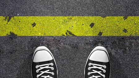 Cross the yellow line Concept illustration showing shoes in front of a yellow line.の写真素材
