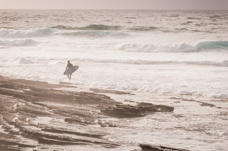 Surfer on rocky shoreの写真素材