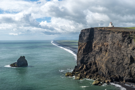 Dramatic view of Icelandic costal landscape with white Lighthouse.の写真素材