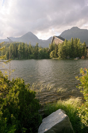 Vertical view of beautiful mountain landscape with hotel next to a lake. Strbske Pleso Town in High Tatras National Park, Slovakia.の写真素材