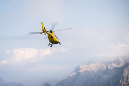 Medical rescue helicopter in air. Italian Dolomites.の写真素材