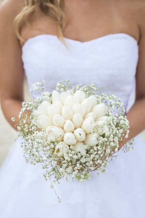 The bride holds a beautiful wedding bouquet of white flowers.の写真素材
