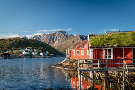 Red Classic Norwegian Rorbu fishing huts with sod roof on Lofoten islands. Norwegian traditional type of house used by fishermenのeditorial素材