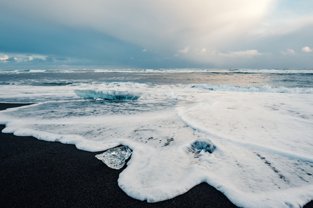 Ice on the black volcanic beach near Jokulsarlon glacier lagoon, winter Iceland.の写真素材