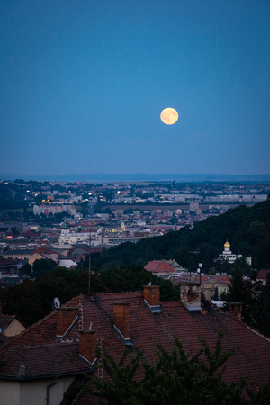 Evening view of Supermoon rising over old town. Night shot of Brno cityscape.の写真素材