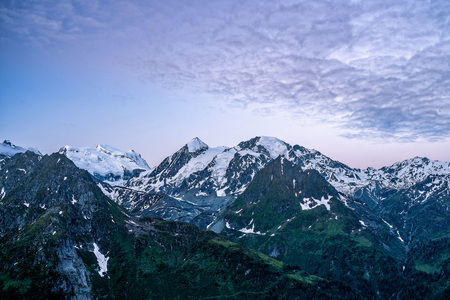 Scenic view of beautiful landscape in Swiss Alps. Fresh green meadows and snow-capped mountain tops...
