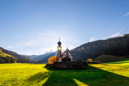 Wonderful Sunny Landscape of Dolomite Alps. St Johann Church, Santa Maddalena, Val Di Funes, Dolomites, Italy. Fairy velley in Dolomites mountains under sunlit. Amazing nature Background.の写真素材