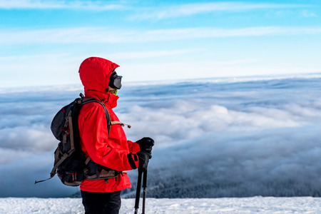 Winter sport activity. Woman hiker hiking with backpack and snowshoes snowshoeing on snow trail...