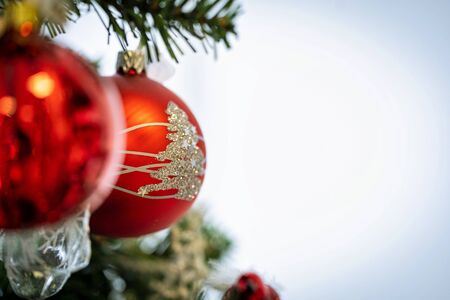 Christmas background. Detail view of red and silver baubles and festive decorations hanging on a green christmas tree.の写真素材