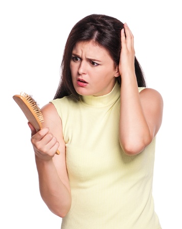 Shocked woman discover how much hair loss on hairbrush isolated on white backgroundの写真素材