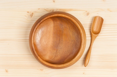 Empty bamboo bowl with spoon on a wooden surfaceの写真素材
