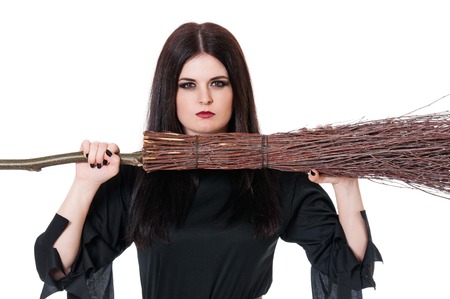 Upset witch with broom over white background close-up
