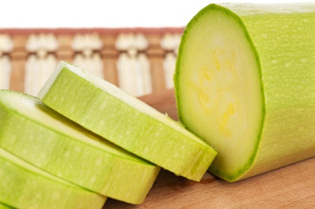 Circles of fresh vegetable marrow on a cutting board close-upの写真素材