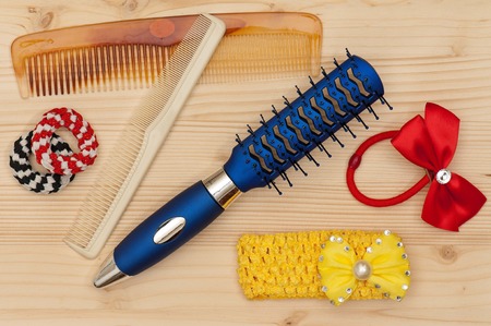 New hairbrush with accessories over wooden surface