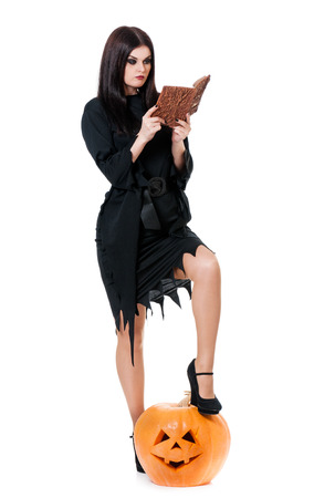 Inquisitive witch with book for spells isolated on a white の写真素材