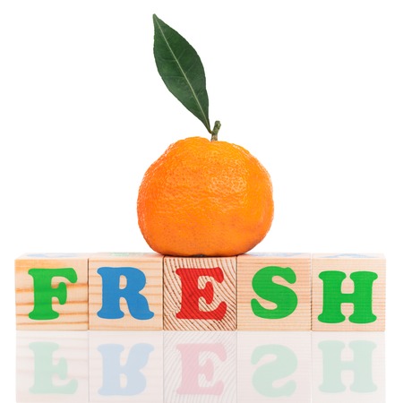Fresh ripe tangerine with playing cubes isolated over white backgroundの写真素材