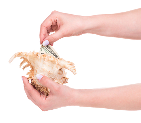 Young female hand with cash and cockleshell isolated over white backgroundの写真素材