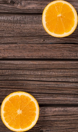 Bright orange slices over wooden background with empty space for your text. Focus on the orangeの写真素材