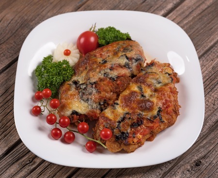 Baked chicken breasts with garnish on the old wooden surfaceの写真素材