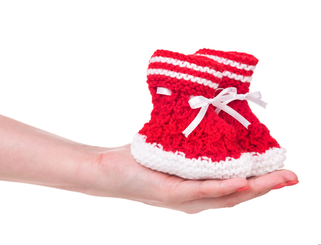 Cute little bootee in the female hand isolated over white backgroundの写真素材