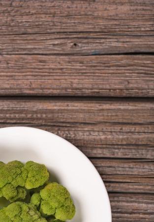 Boiled green broccoli over old wooden background with empty space for a textの写真素材