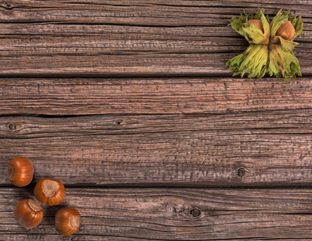 Ripe delicious filberts over old wooden background with empty space for textの写真素材