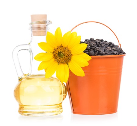 Sunflower oil with flower and seeds isolated over white backgroundの写真素材