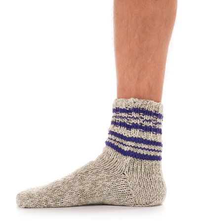 Legs of caucasian man in knitted warm socks over white backgroundの写真素材