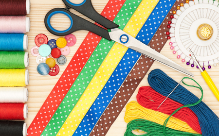 Bright sewing accessories over wooden surface close-upの写真素材