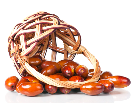 Raw jujube fruit in the wattled basket isolated on white backgroundの写真素材