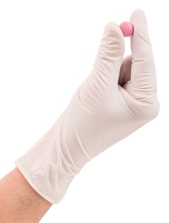 Pink pill in the woman hands isolated over white backgroundの写真素材