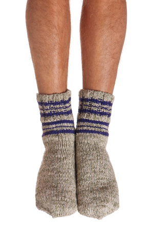 Legs of caucasian man in knitted warm socks over white backgroundの写真素材
