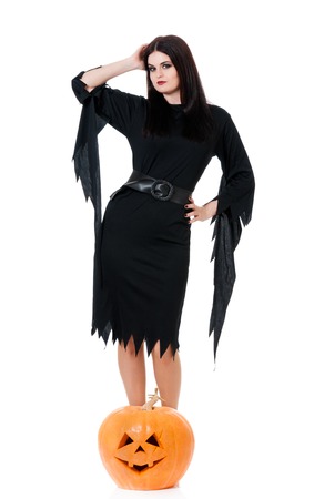 Young beautiful witch with pumpkin over white backgroundの写真素材