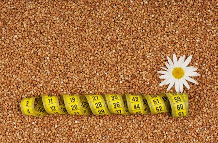 Raw buckwheat seeds background with tape measure closeupの写真素材