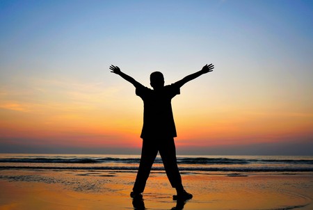 Man fell freedom on the beach at sunset