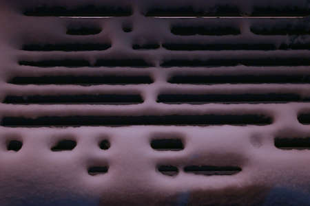 Snow-covered park bench in night parkの写真素材